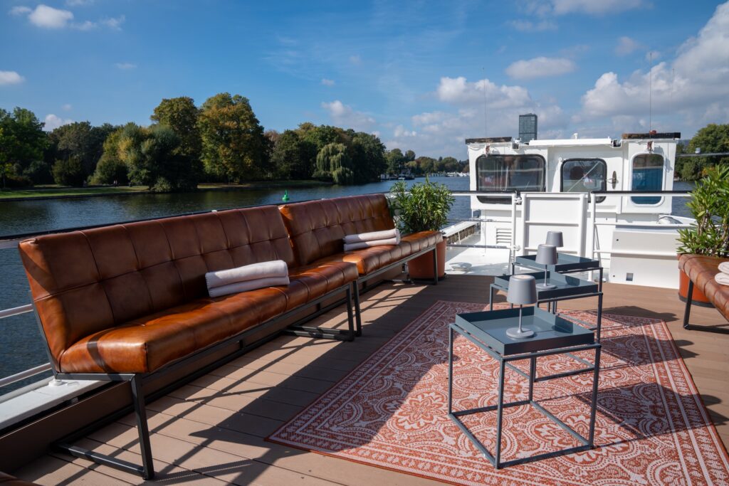 Eventschiff 2: Lounge-Terrasse auf dem Oberdeck mit Ledersofas und Teppich